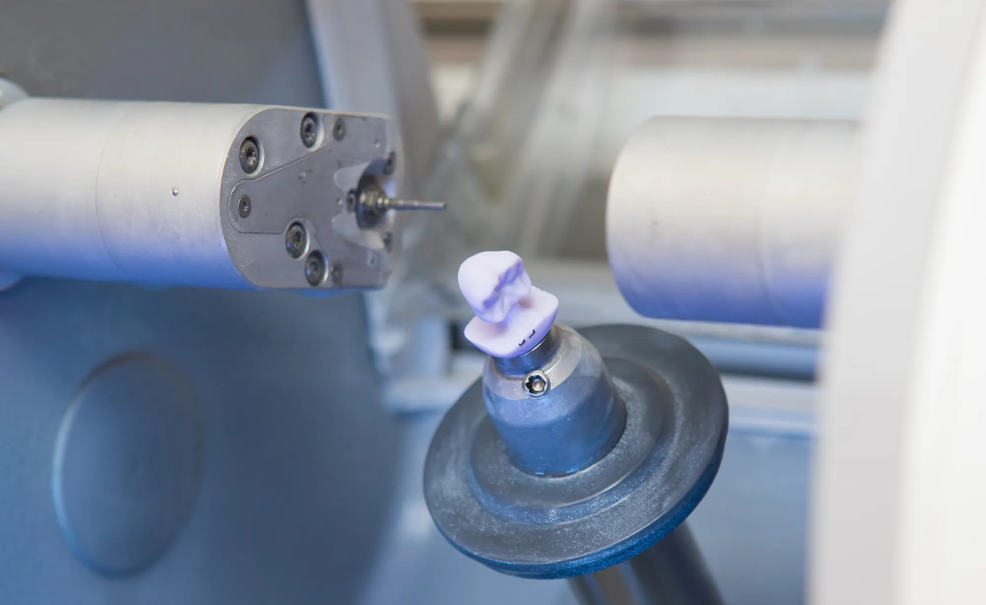 A tooth restoration being milled in a CEREC milling machine