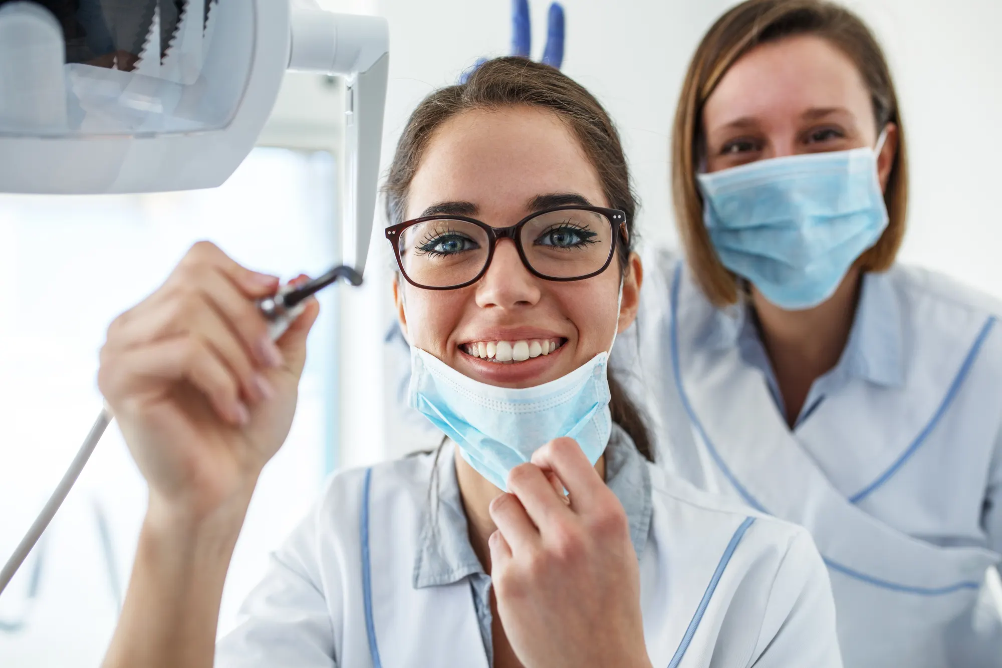 Two dentists examining a patient, seen from the patient's point of view