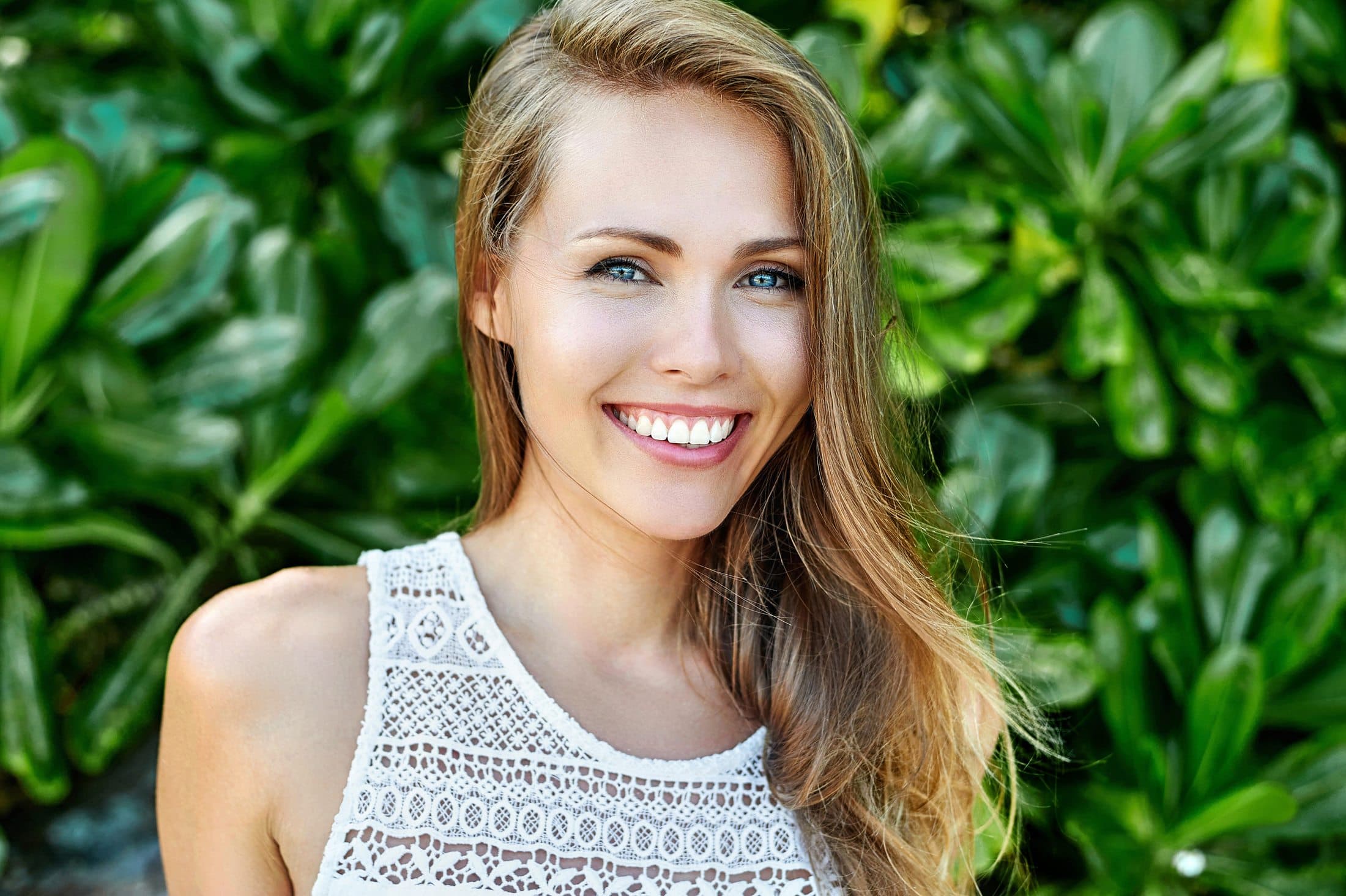 A woman smiling outdoors in the sunshine